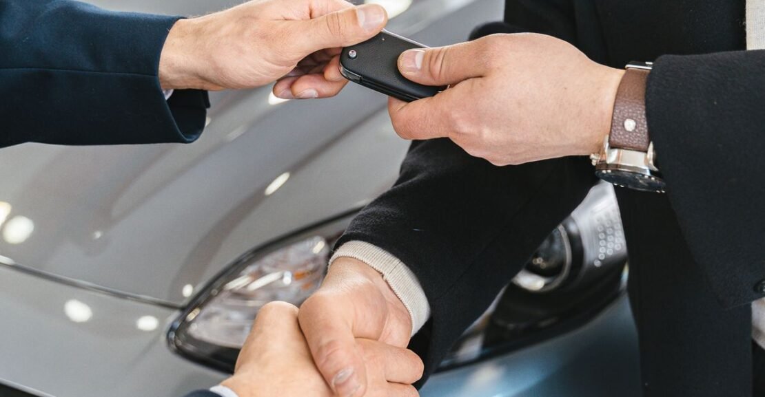 Buyer signing for a new car at a dealership — car loan interest deduction 2026