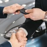 Buyer signing for a new car at a dealership — car loan interest deduction 2026