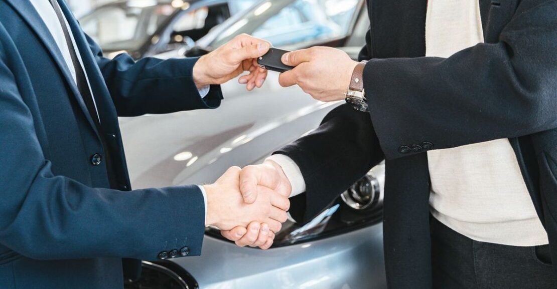 Lease vs buy a car in 2026 — new car keys being handed over at a dealership