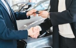 Lease vs buy a car in 2026 — new car keys being handed over at a dealership